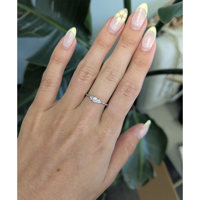 This elegant Earth mined diamond ring features a brilliant 4mm round center diamond enhanced with delicate diamond...