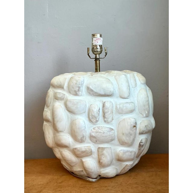 This vintage table lamp is a tactile, sculptural piece, built as a plump, rounded drum covered in a mosaic of natural...