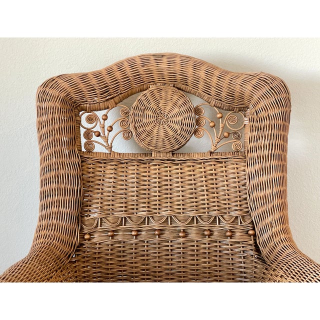A beautiful and classic chair, adult-sized. Composed of natural wicker and rattan with decorative rosettes and a medallion...