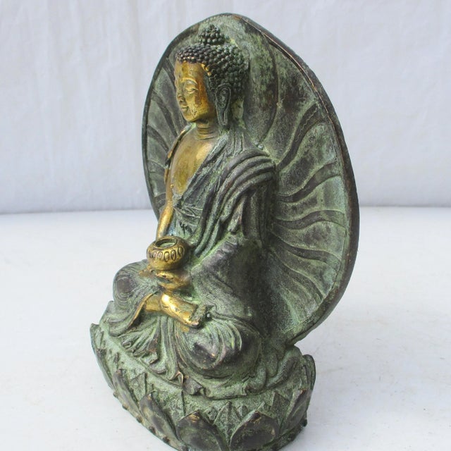 Small verdigris and gilt seated Buddha. Charming and beautifully made bronze Buddha with mandorla surrounding the seated...
