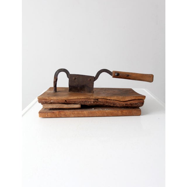 This antique tobacco cutter, with its worn wood and sturdy blade, evokes the bustling atmosphere of a country general...