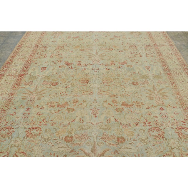 Hand-knotted in wool, circa 1920-1930, this 8x12 antique Tabriz rug is a refined example of one of the most celebrated...