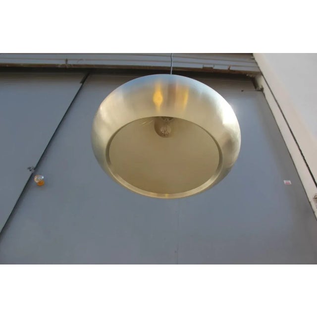 This minimalist metal ceiling lamp is from the 1960s. Up to 250V (Europe/UK Standard).The wiring of this item may be...