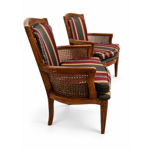 A handsome matching pair of vintage French Provincial and Directoire-style armchairs, likely dating to the late 20th...