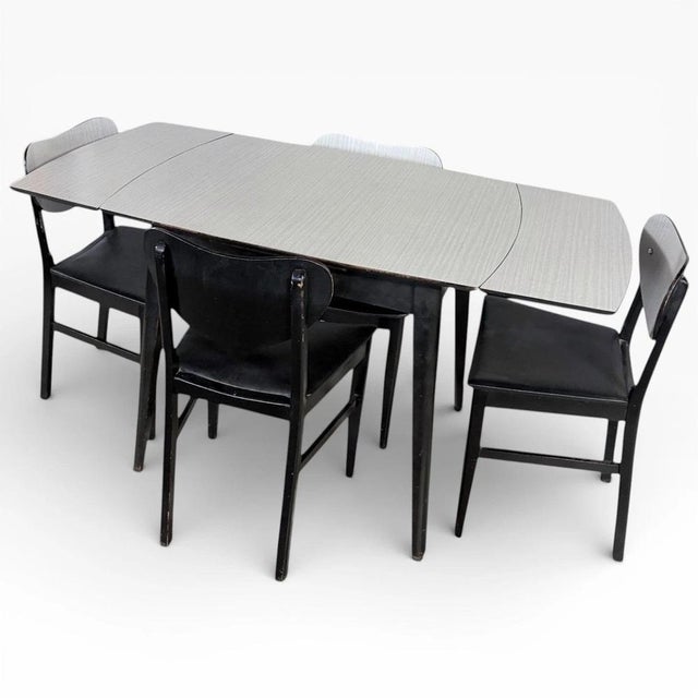 This vintage drop-leaf dining table offers a perfect blend of style and function for any mid-century dining space....