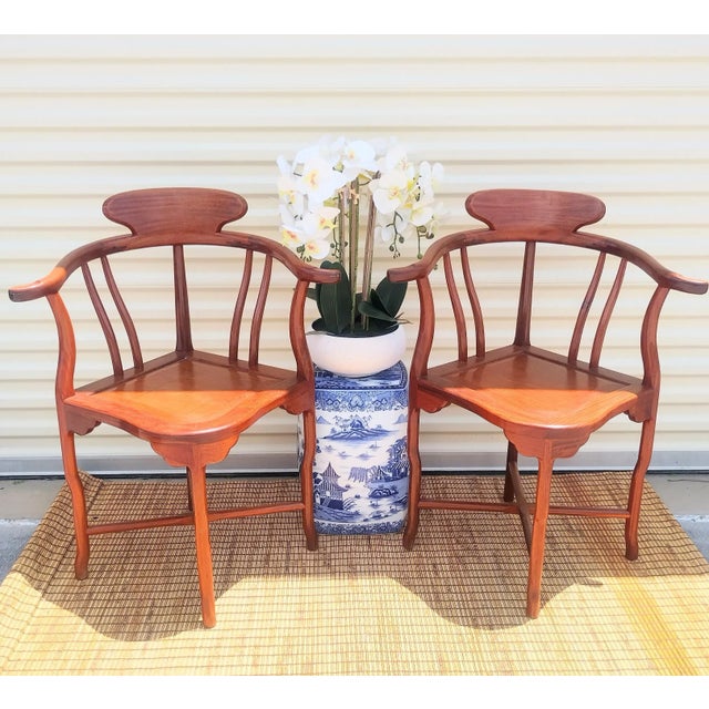An incredible pair of Mahogany corner Asian chinoiserie style corner side chairs. The chairs have simple lines with slight...