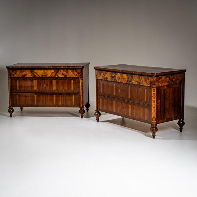 Pair of Italian chests on baluster legs with three drawers and side arabesque marquetry. Top drawer veneered in burl wood,...