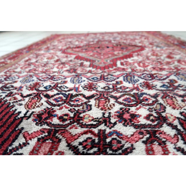 A handmade antique Persian Hamadan rug from the 1920s, woven in wool and displaying the bold geometric character typical...