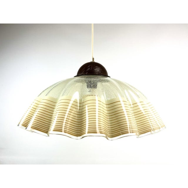 Atmospheric hanging lamp, decorated with an attractive pattern in warm colours on wavy glass. In excellent condition....