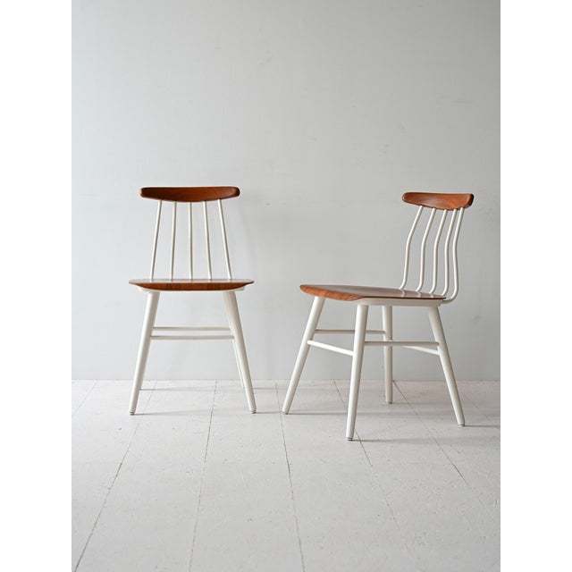 Set of two Scandinavian chairs from the 1960s with a shaped wooden seat and a white painted wooden frame. The distinctive...