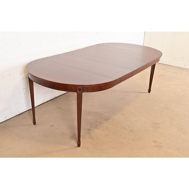 A beautiful Federal or Hepplewhite style extension dining table By Kindel Furniture USA, Circa 1980s Gorgeous book-matched...