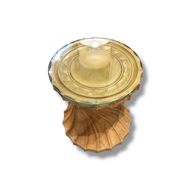 This pre-loved accent table features a sculptural solid wood base with beautifully carved, flowing lines that create a...