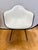 A striking set of four vintage Herman Miller molded shell arm chairs featuring original white upholstery with contrasting...