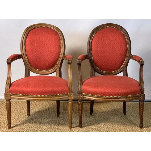 A near pair of French Louis XVI beechwood fauteuils, one dating from the late 18th century, the other made to match some...