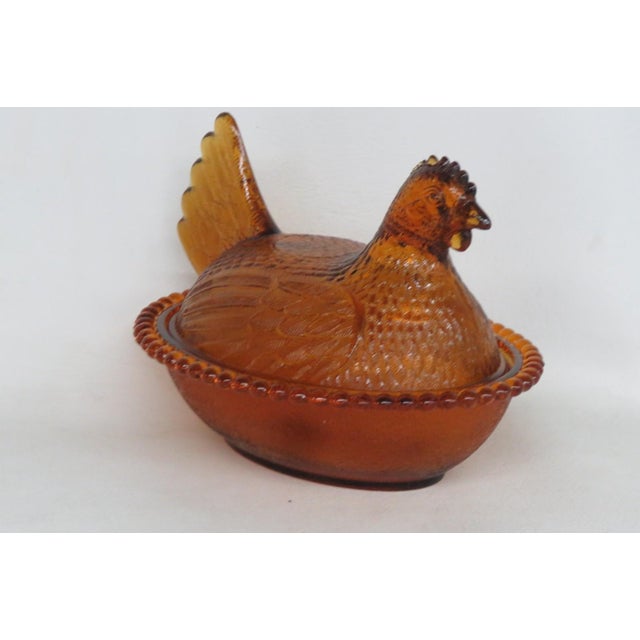 This lovely Lidded Candy Dish is made of glass. This piece presents an amber color throughout the piece with a depiction...