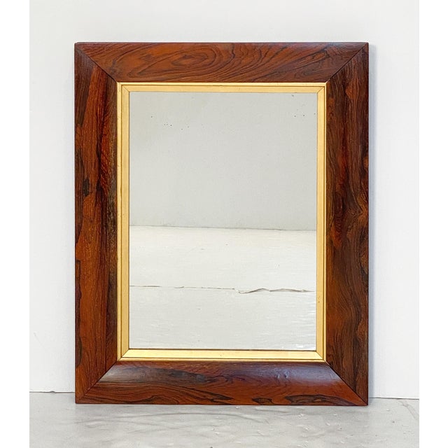 A fine English rectangular wall mirror from the 19th century, featuring an ogee frame of figured wood with a giltwood slip...