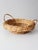 A vintage round wicker basket with a broad woven rim, raised base, and two loop handles. Beautifully varied natural wicker...