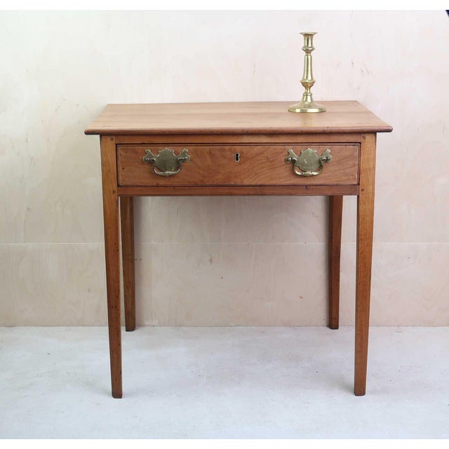 Elegant fruitwood side table with single drawer Lovely rich colour Antique brass handles. Possibly not original.