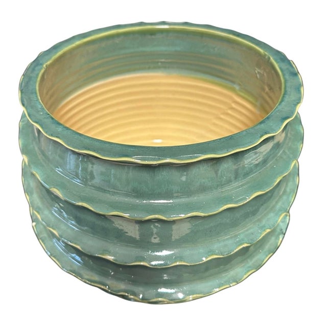 This piece features an accordion-style, ribbed, or "zigzag" tiered design with a scalloped top edge. It is characterized...