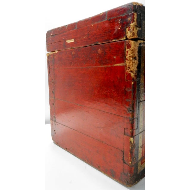 Vibrant red sings on this stunning wooden box from the 19th century. It is highlighted with flowers in black and gold...
