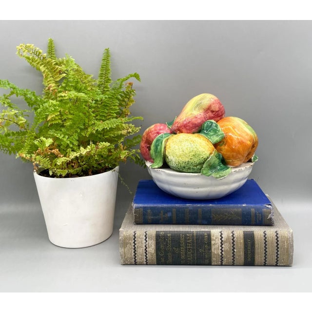 Stunning bowl of ceramic fruit, likely made in Italy. Mid-late 20th century piece. Features gorgeous pink, yellow and...