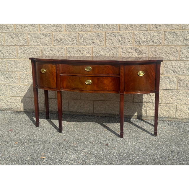 Elegant vintage Thomasville sideboard featuring a graceful bowfront silhouette, richly figured mahogany finish, and...