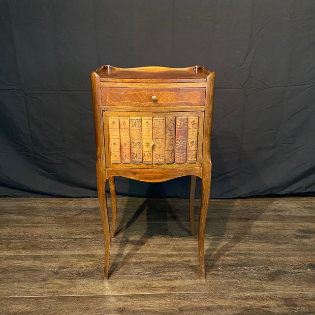 Elegant French Louis XV side table distinguished by an unusual faux book-front cabinet door, cleverly designed to resemble...
