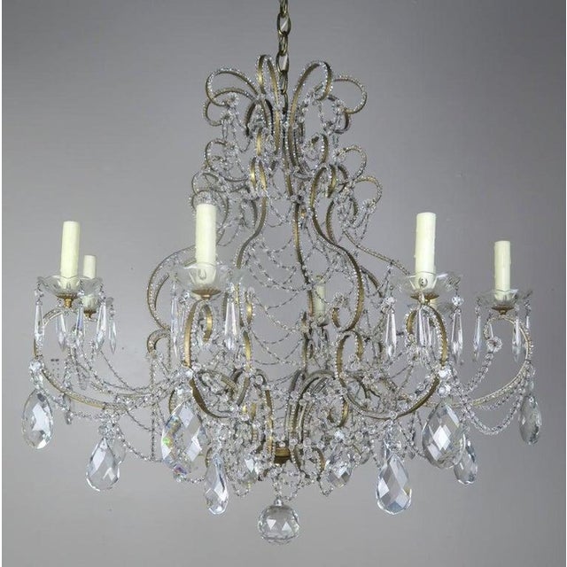 French crystal beaded 8-arm chandelier with faceted almond shaped crystals throughout. The fixture is adorned with...