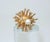 C.1970 Sarah Coventry cocktail ring with a starburst style in a gold tone metal accented by a faux pearl and rhinestone....