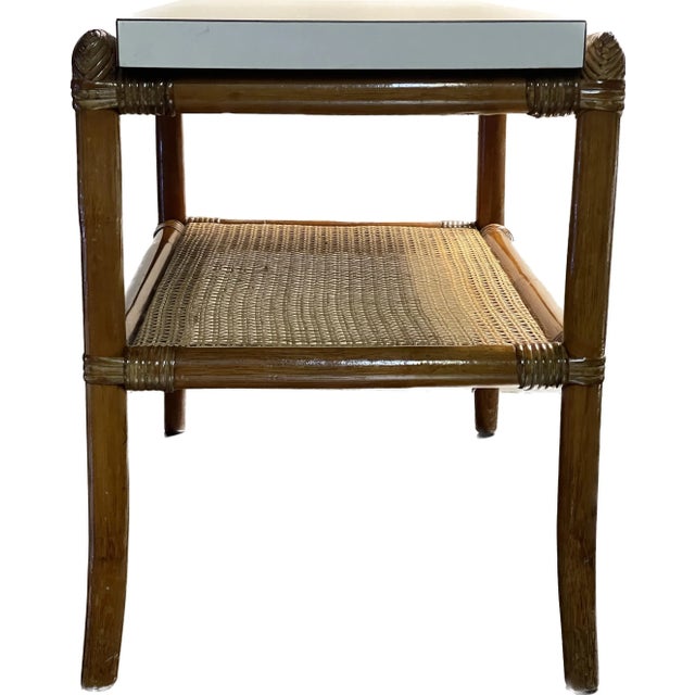 A beautifully proportioned pair of vintage rattan and cane end tables featuring clean white finished tops and a classic...