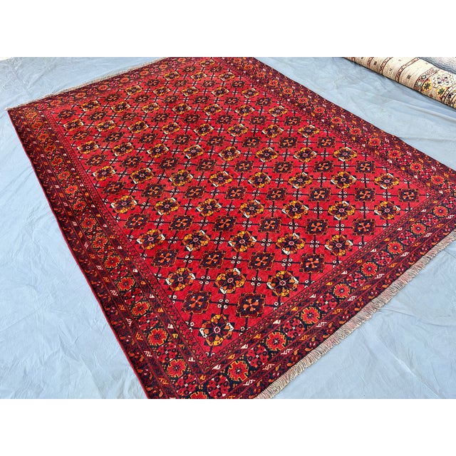 This vibrant Andkhoy rug features an allover repeat of small floral rosette medallions in gold, orange, and navy,...