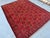 This vibrant Andkhoy rug features an allover repeat of small floral rosette medallions in gold, orange, and navy,...