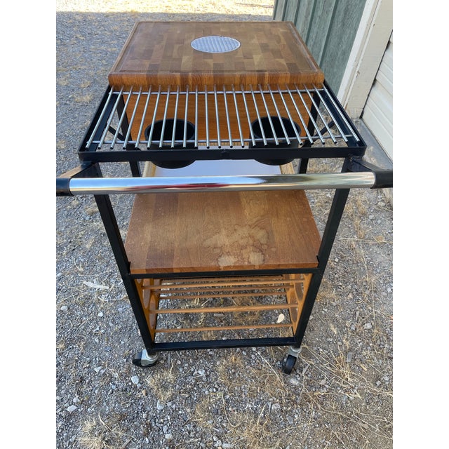 Arthur Umanoff bar cart. It features a black iron frame, butcher block, wicker. Designed for serving and storage, with...