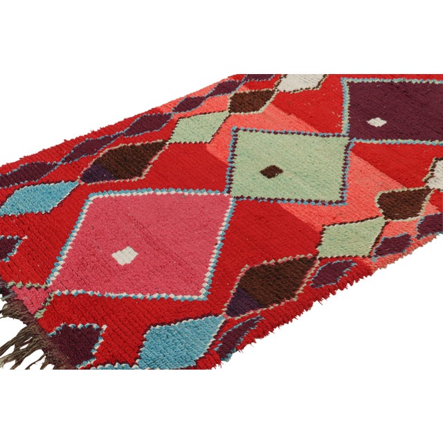 Hand-knotted in wool and originating from Morocco circa 1950-1960, this 3x7 vintage Moroccan rug is an extremely rare...