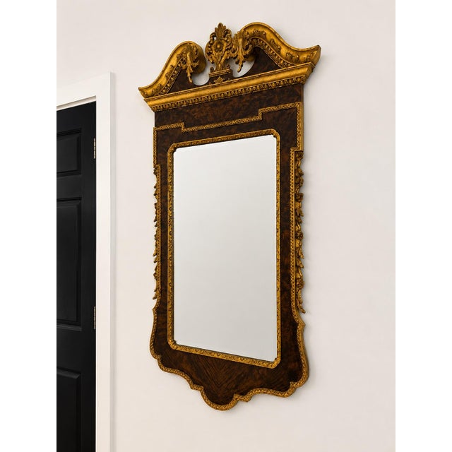 Striking Italian Georgian style wall mirror featuring an exceptionally ornate carved and parcel-gilt frame with a rich...