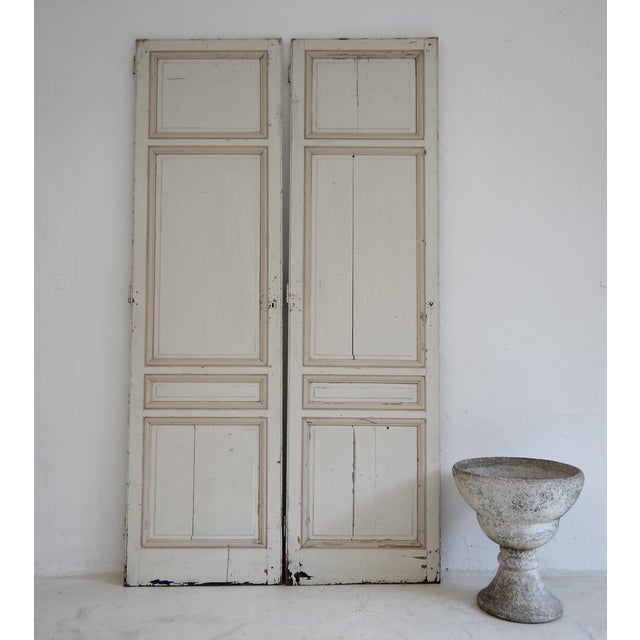 A pair of doors from a late 19th century built-in wardrobe. Unrestored with original color in light cream with contrasting...