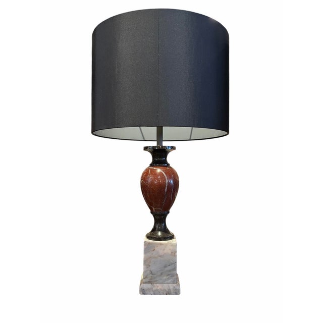 An elegant pair of Donghia table lamps showcasing a striking combination of tri-color marble construction. The contrasting...