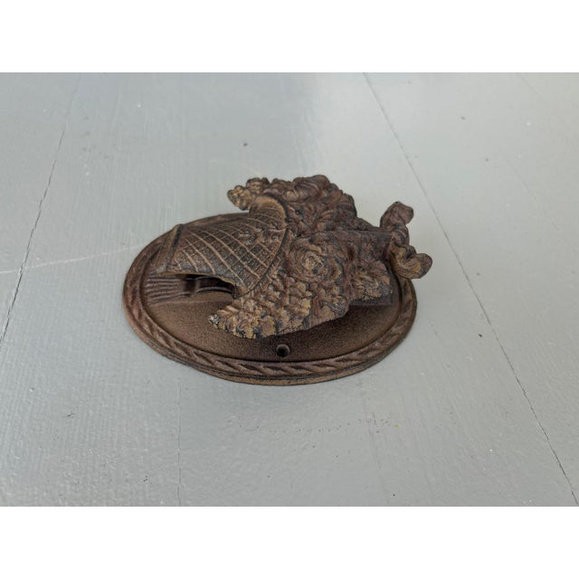 This antique wrought iron door knocker has a lovely basket-of-flowers design with dimensional floral detailing, scrolling...