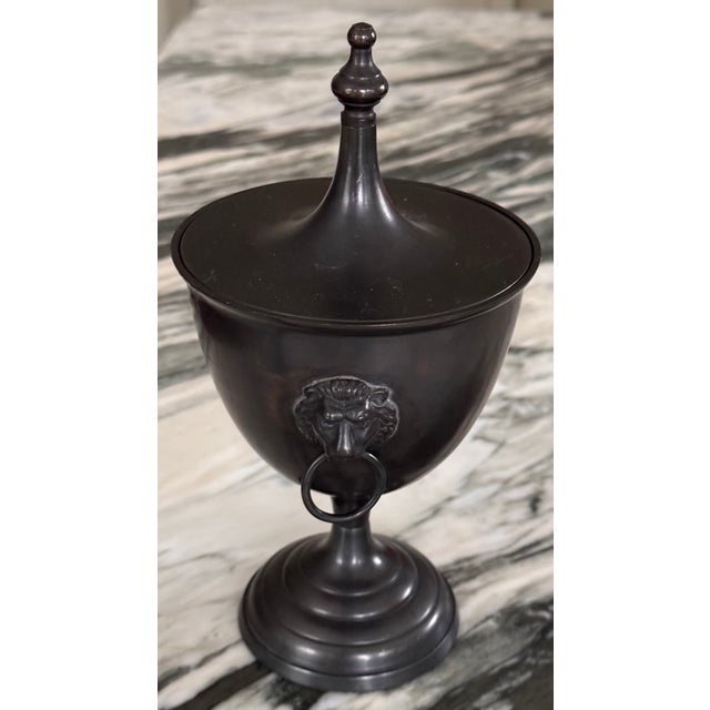 Heavy for its size, here is a bronze finish metal decorative vessel. Featuring a removable lid and neoclassical style lion...