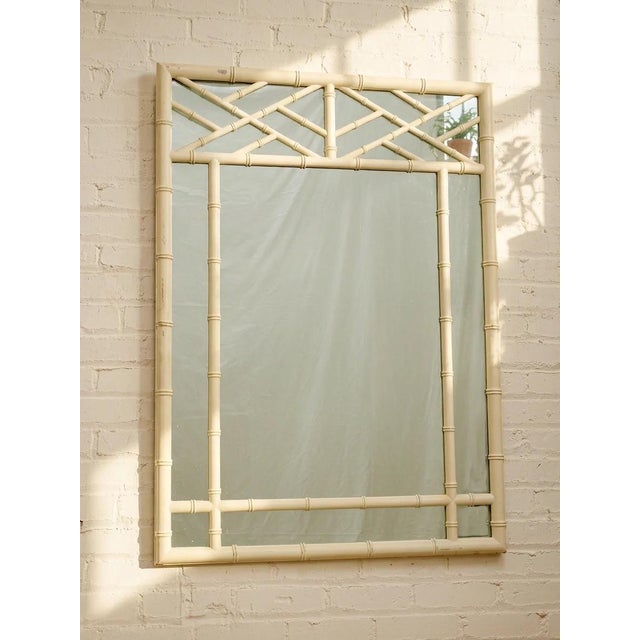 A fantastic vintage wall mirror framed in white faux bamboo with an especially decorative geometric lattice treatment...