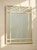 A fantastic vintage wall mirror framed in white faux bamboo with an especially decorative geometric lattice treatment...