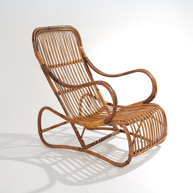 A rattan armchair from the 1950s characterised by a sinuous and highly sculptural structure, constructed through a...