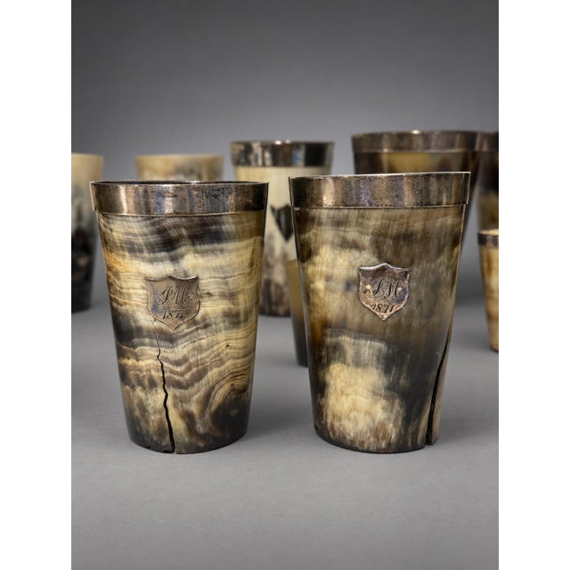 An assembled collection of twenty-four horn drinking beakers, mostly British, predominantly nineteenth century, with...
