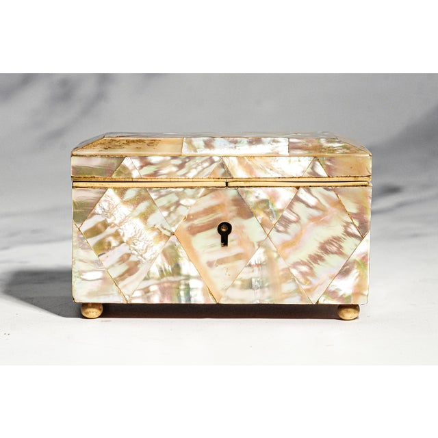 Delicate, luminous, and exceptionally charming, this exquisite 19th-century English mother-of-pearl miniature box is a...