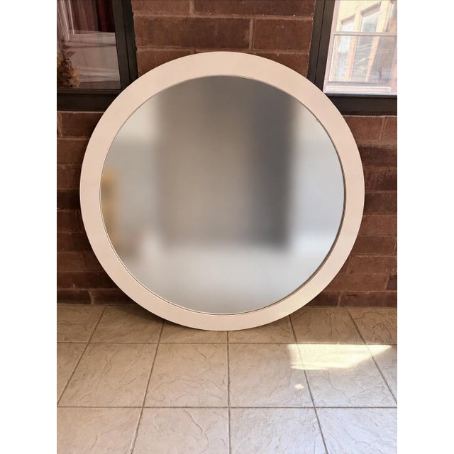 A monumental 1980s round wall mirror featuring a clean, architectural silhouette and a wide 3-inch white laminate frame....