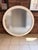 A monumental 1980s round wall mirror featuring a clean, architectural silhouette and a wide 3-inch white laminate frame....