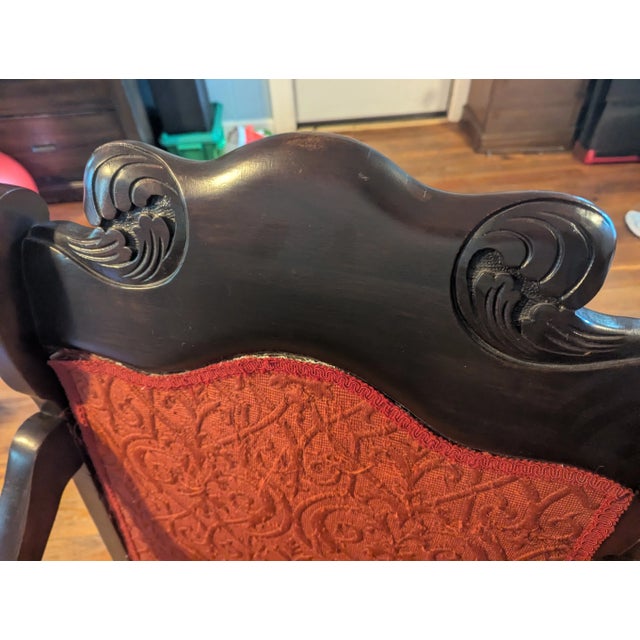 This vintage wooden armchair has a lot of classic character, featuring carved details on the crest rail and curved arms...