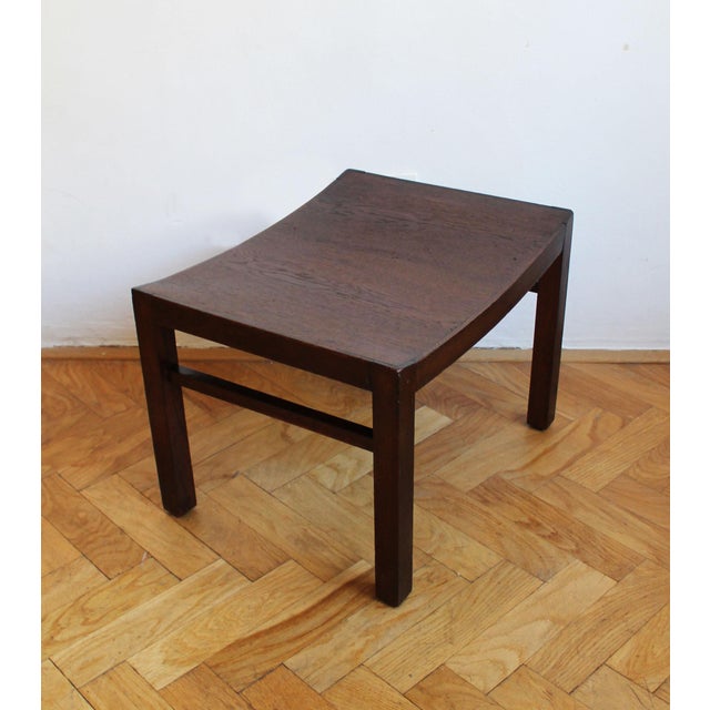 A distinctive solid wood stool made in Czechoslovakia during the 1960s. The design is defined by its sculpted saddle-...