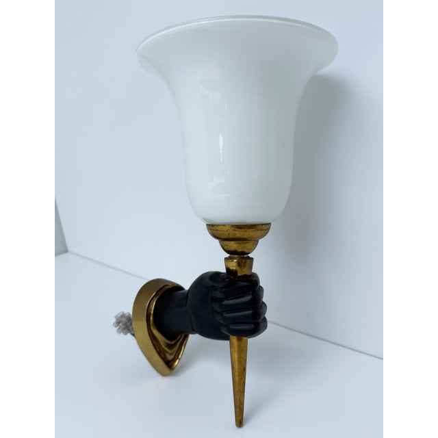 Striking and sculptural Nubian hand wall sconce by noted French artist John Devoluy, featuring a black left hand holding a...