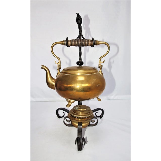 An antique Art Nouveau brass tea kettle and burner on iron stand. Tea kettle is stamped S&C Company which was standard for...